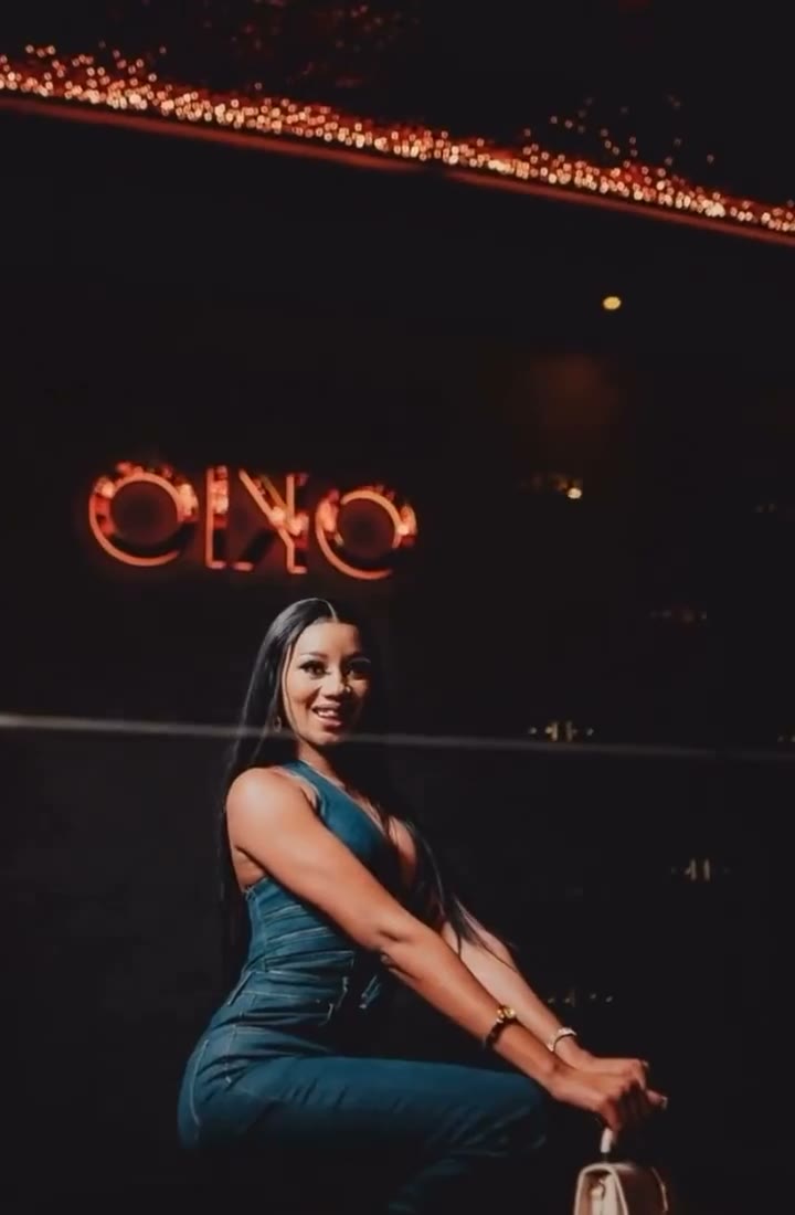 A DJ under the neon OKIO sign